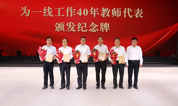 3.吴普特为一线工作40年的教师代表颁发纪念牌.jpg